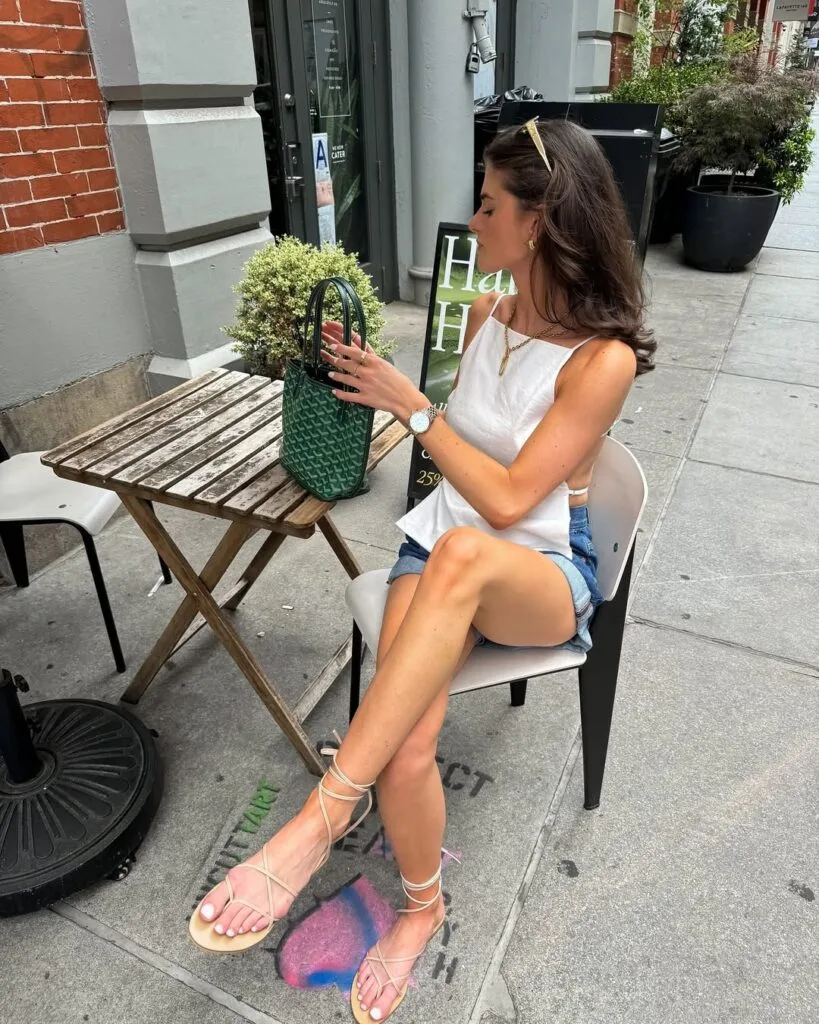 White asymmetrical top denim shorts and green handbag summer outfit