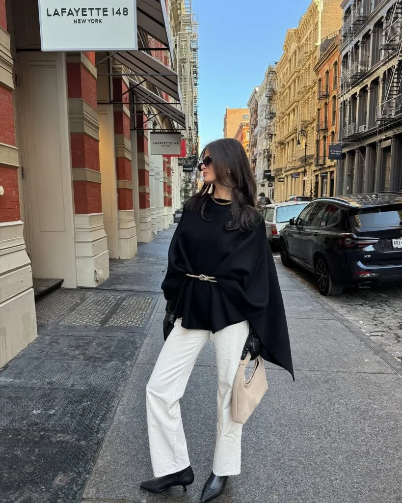 Black belted poncho white trousers and boots New York outfit