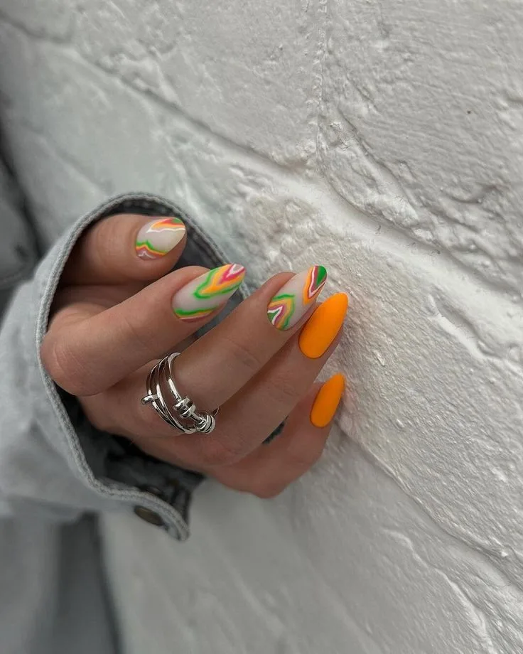 Neon wave August nails with bright swirling patterns and bold colorful accents.
