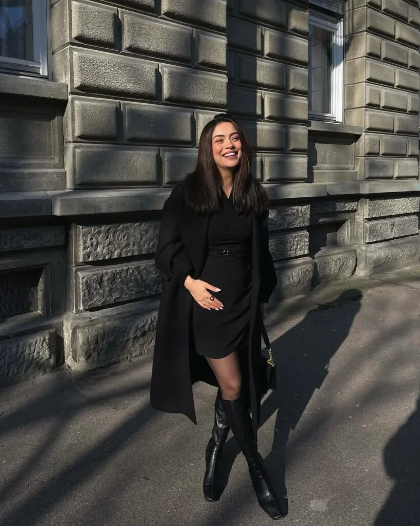 Long black coat over belted mini dress
