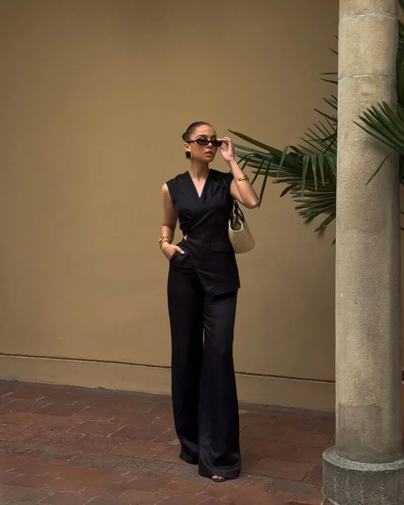 Sleeveless black wrap top with tailored trousers