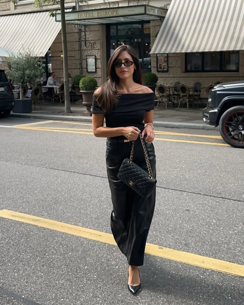 Black off-shoulder top with wide-leg pants and heels