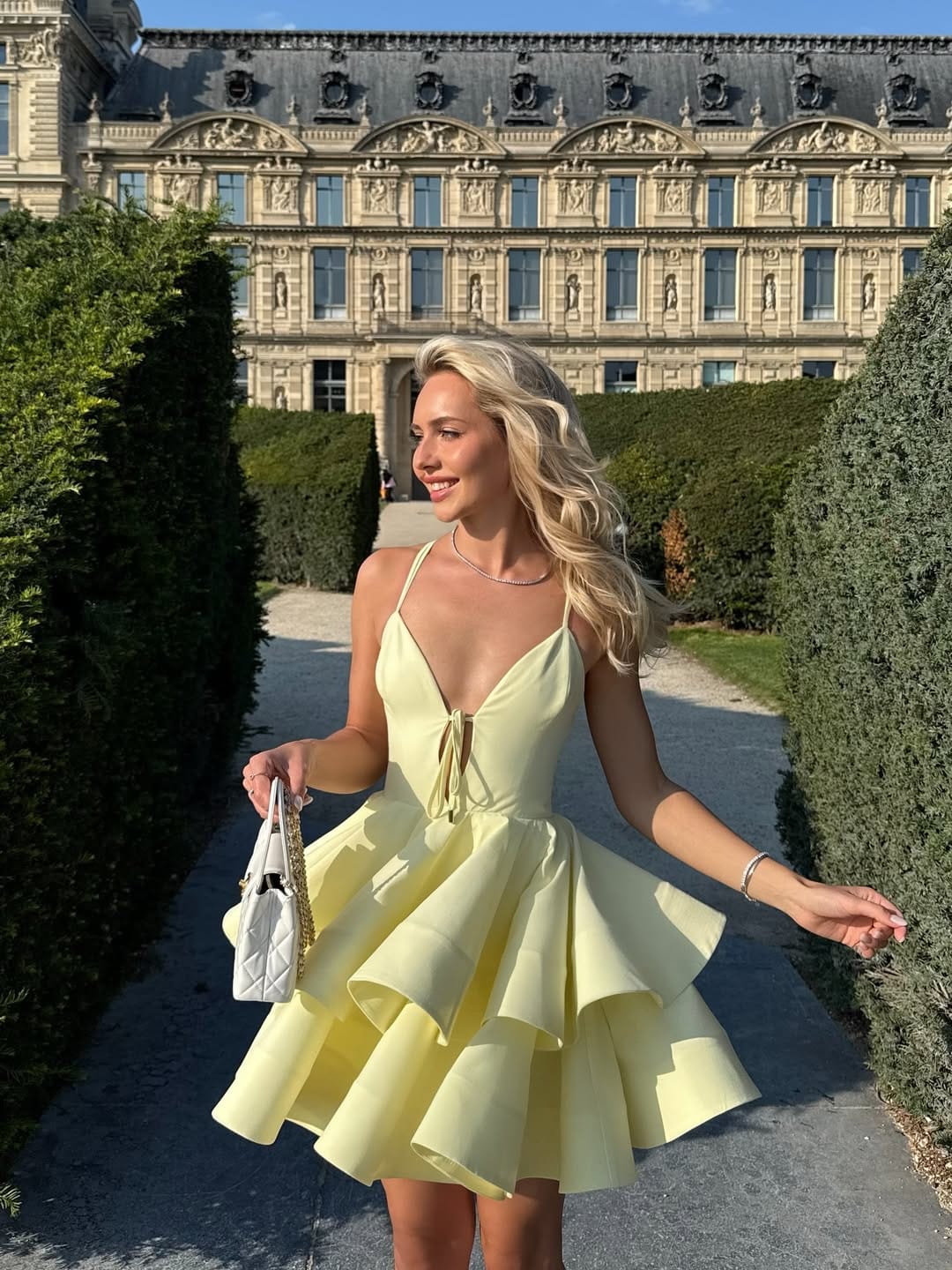 Butter yellow tiered ruffle spaghetti-strap mini dress with pearl necklace