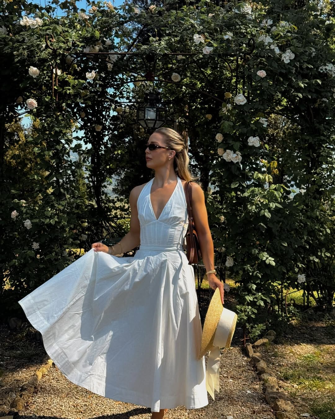 White halter neck midi dress styled with a straw hat for a chic winery look