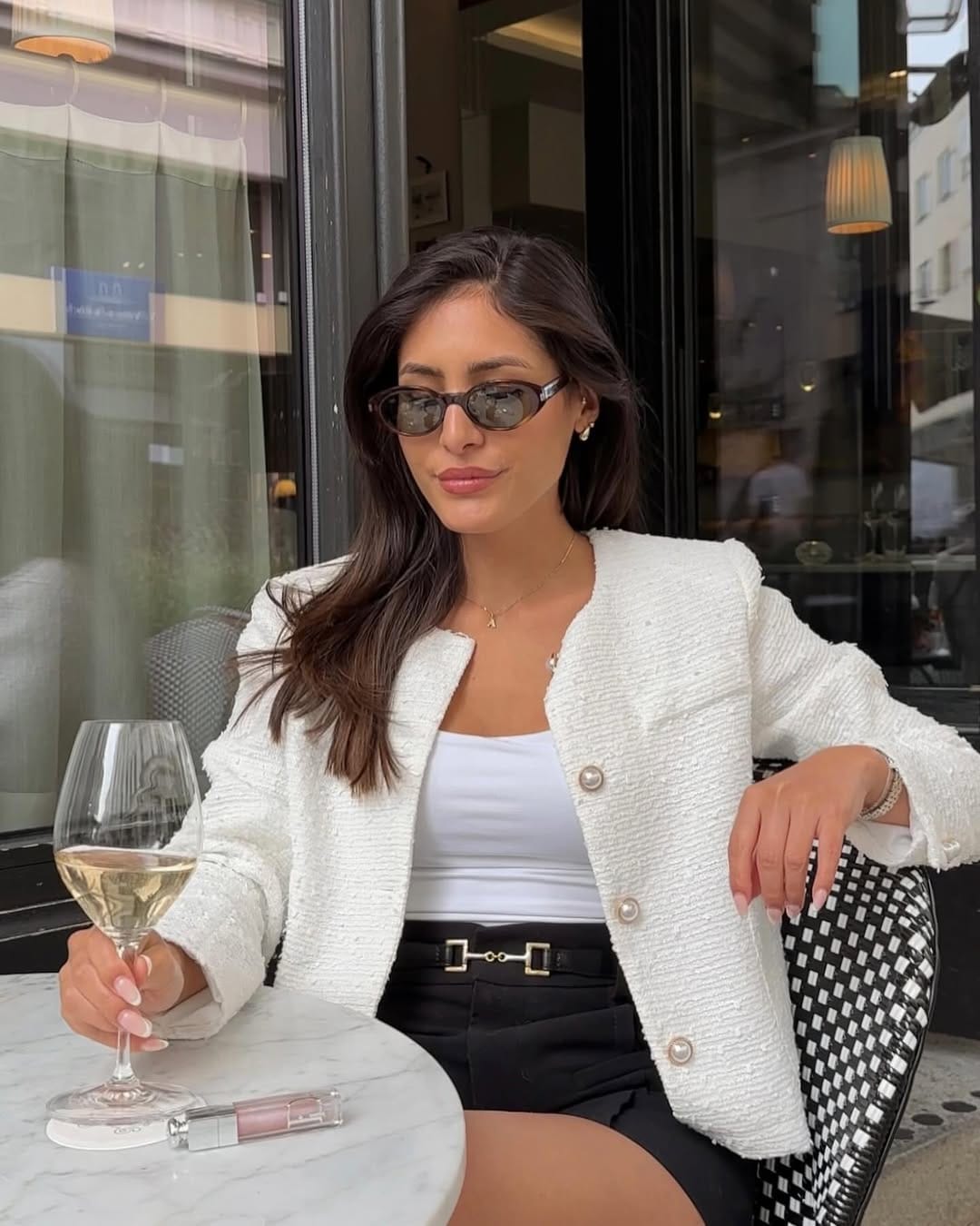 White bouclé tweed jacket paired with black horsebit shorts