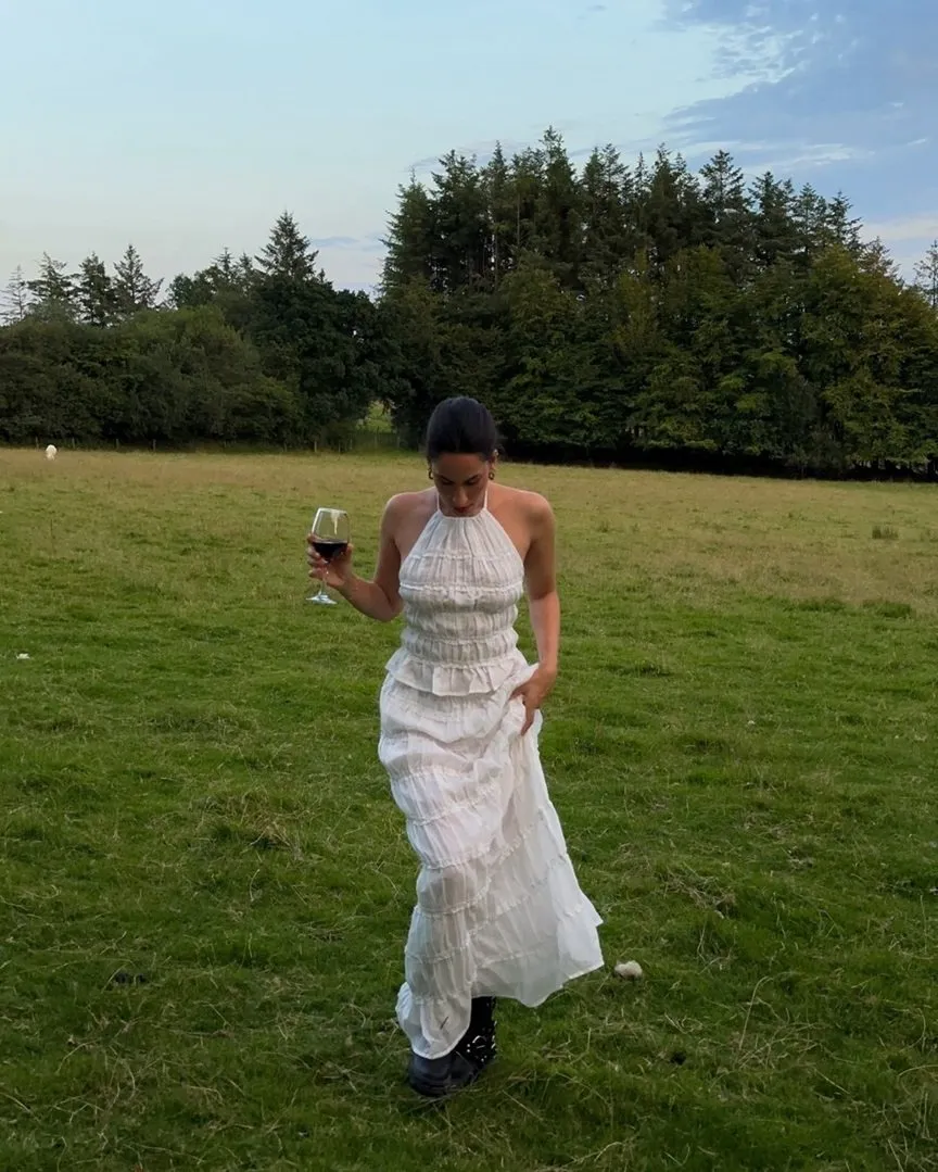 White tiered halter maxi dress styled with black lace-up boots