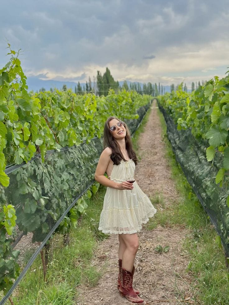 Cream tiered chiffon mini dress styled with burgundy cowboy boots