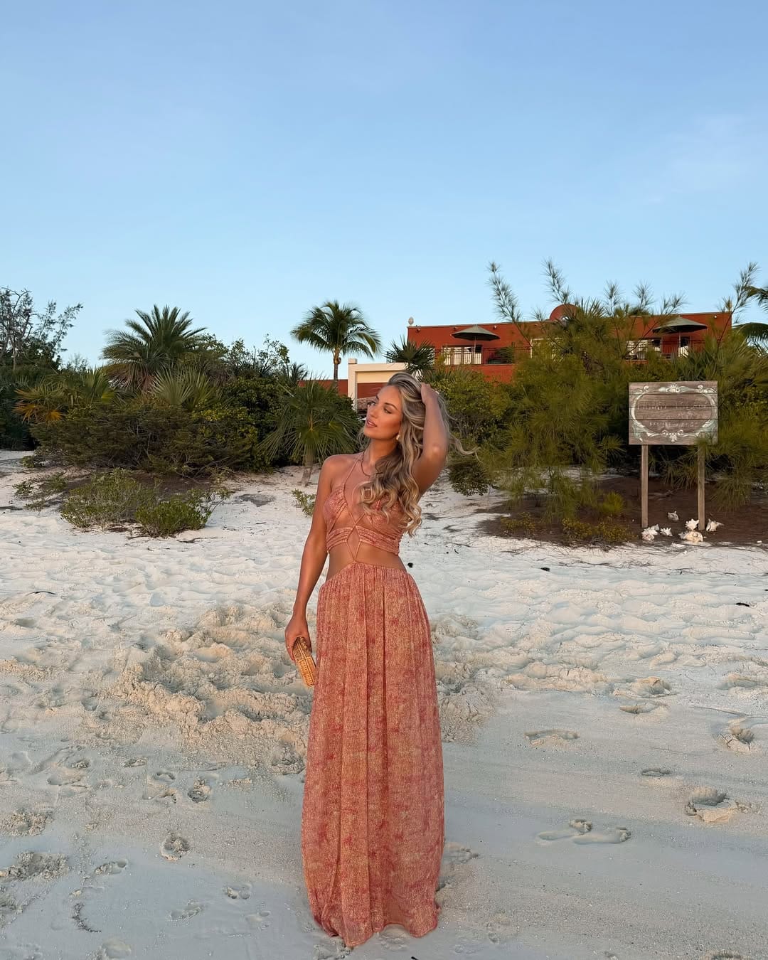 Terracotta halter lace crop top with matching pleated maxi skirt on white sand beach outfit idea