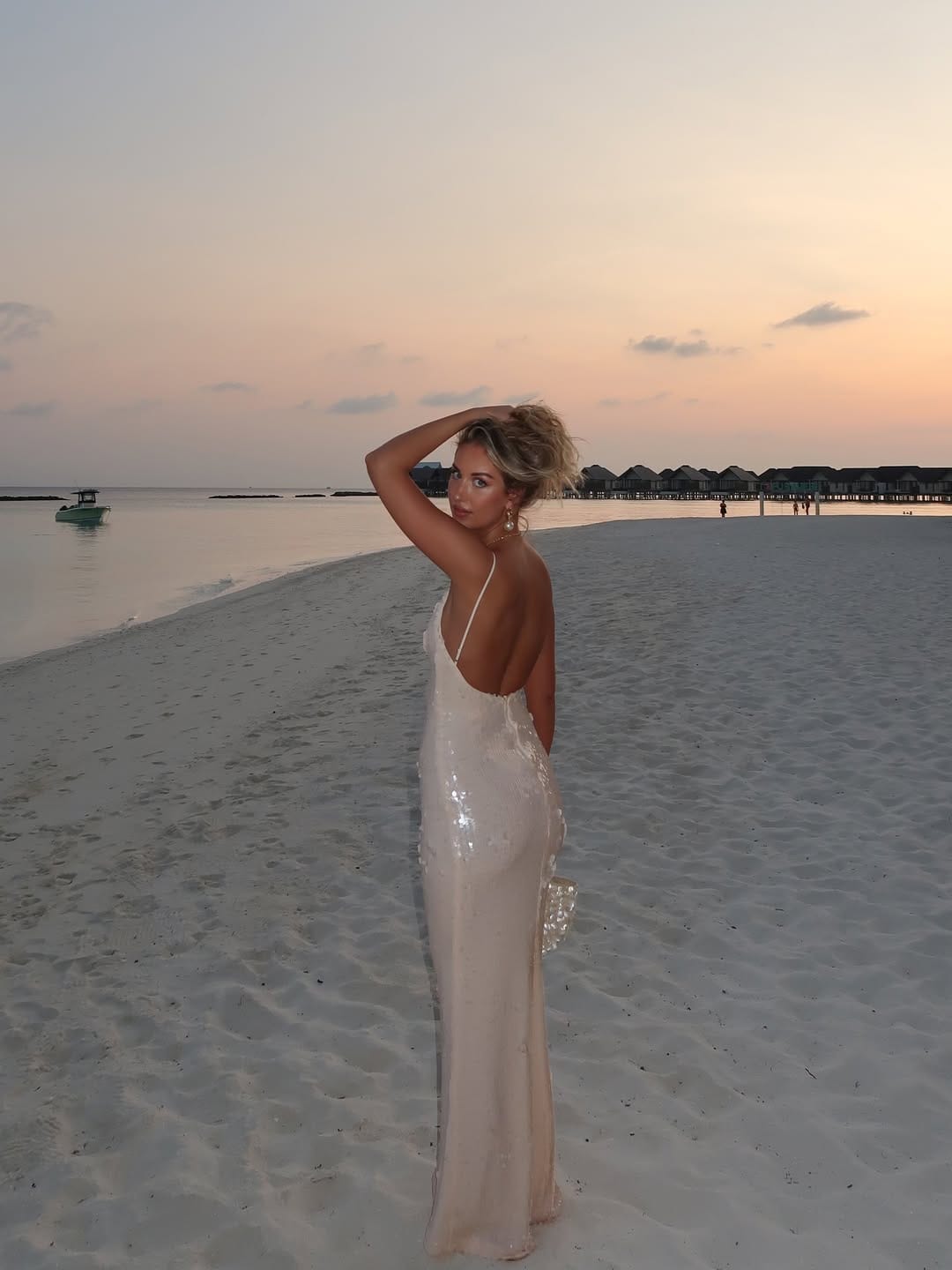 White sequin open-back slip maxi dress with pearl earrings on Maldives beach at sunset beach outfit idea