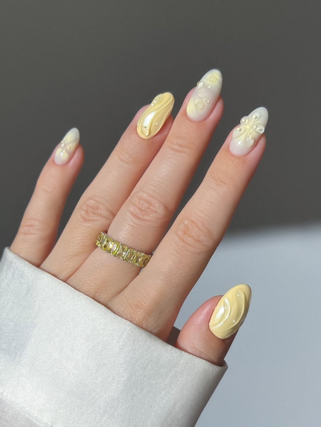 Butter yellow almond nails with 3D swirl design and pearl accents