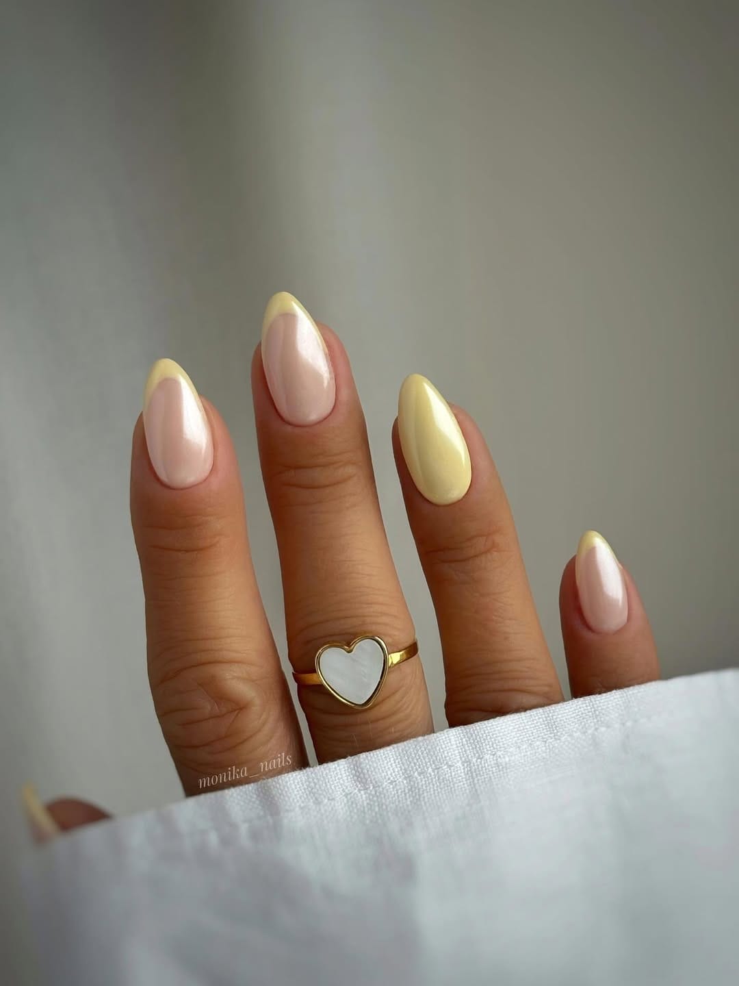 Butter yellow almond nails with pearl chrome finish