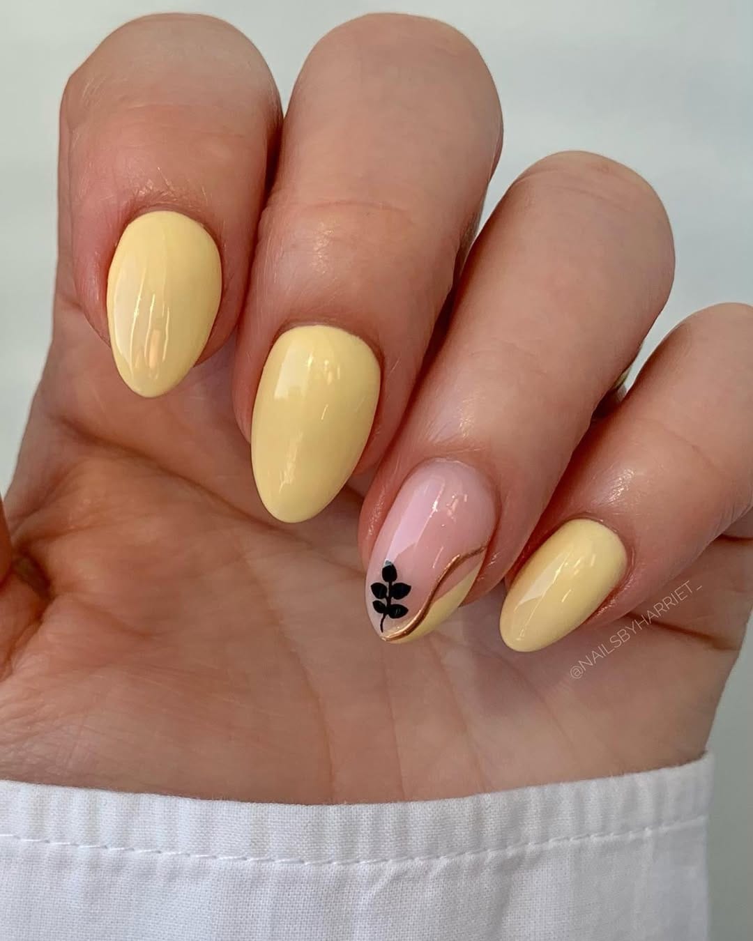 Butter yellow nails with sheer black botanical accent designs