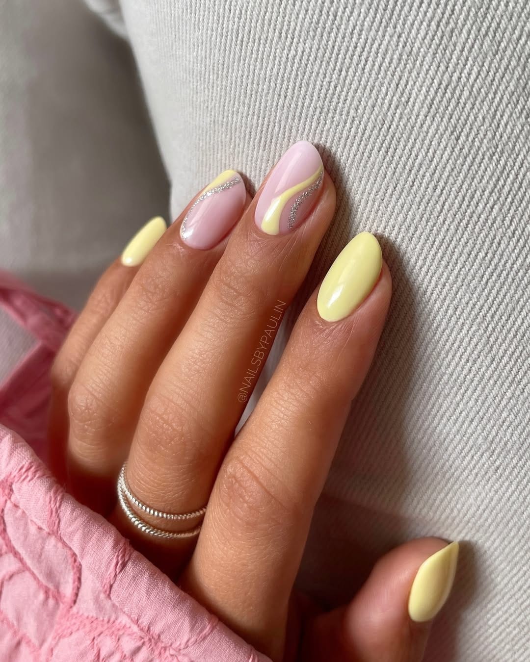 Butter yellow and pink swirl almond nails with silver glitter detail