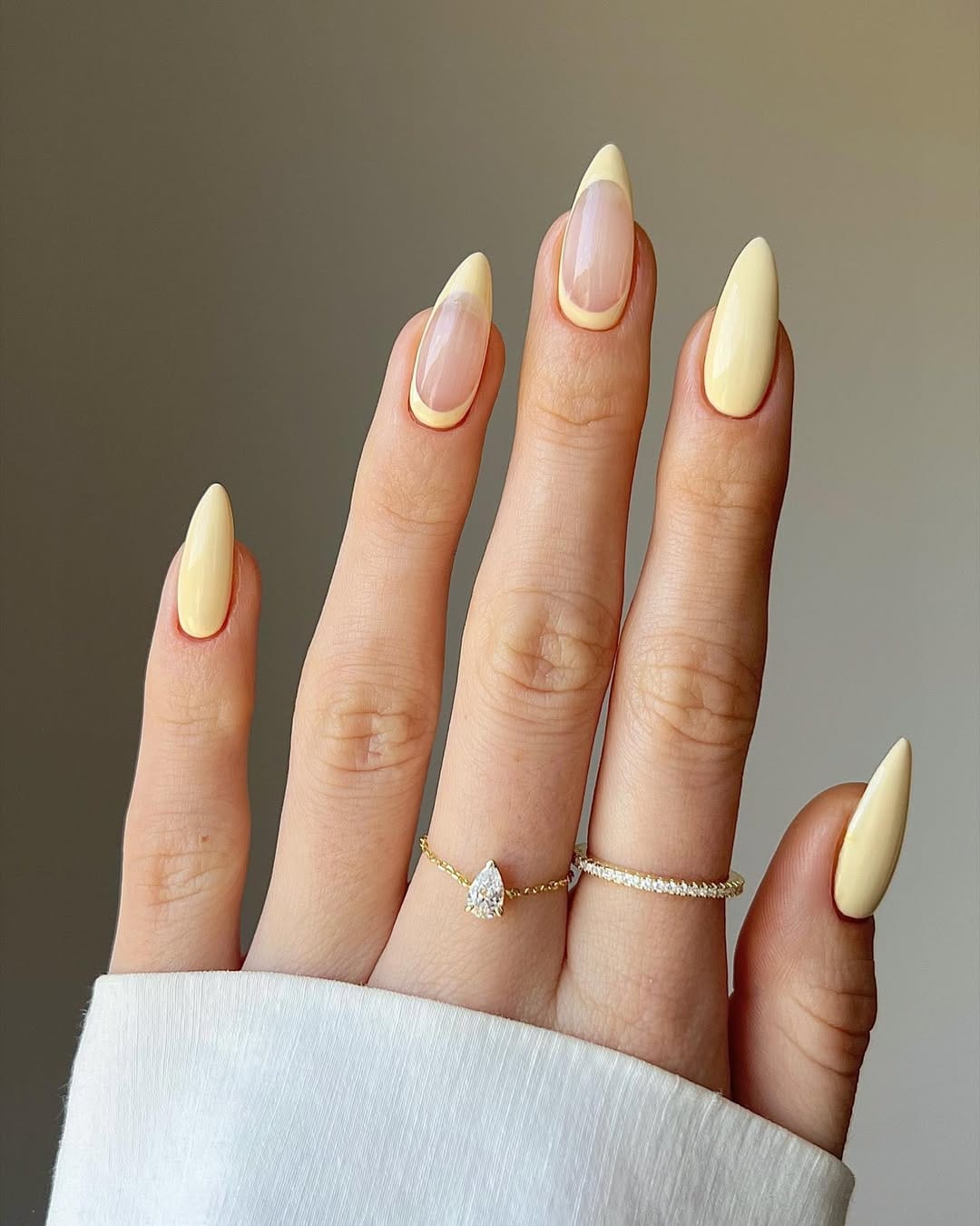 Butter yellow almond nails with a mix of French tips and solid colors