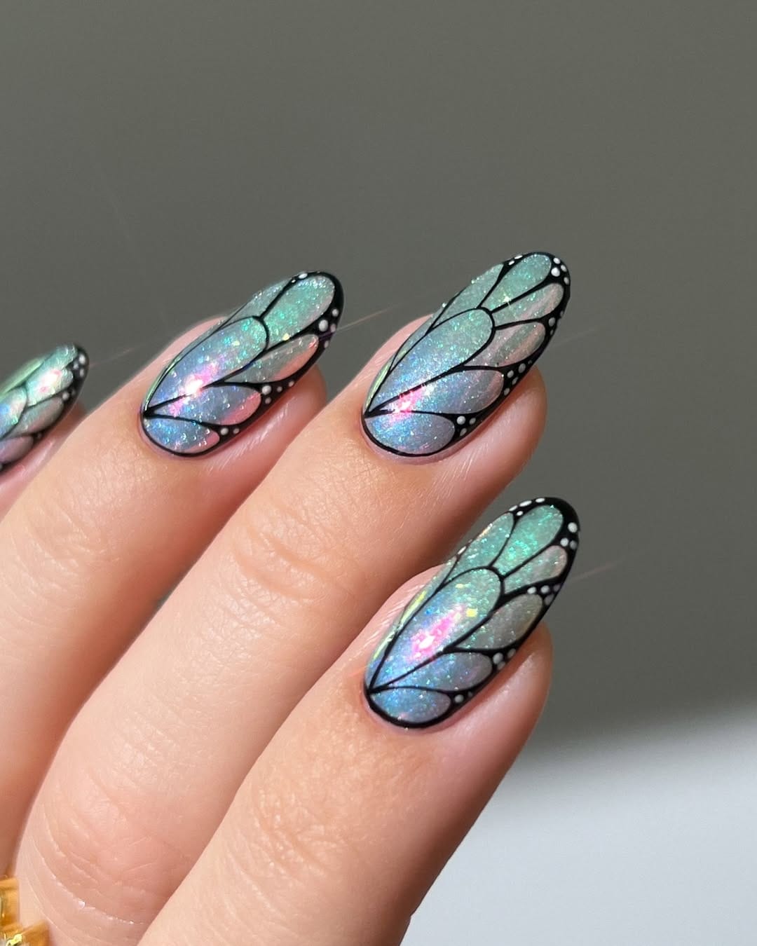 Holographic teal almond nails with full butterfly wing coverage