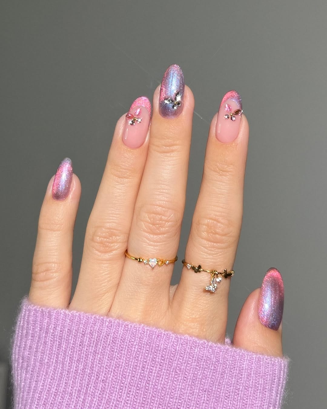 Pink violet duochrome almond nails with rhinestone butterfly charms