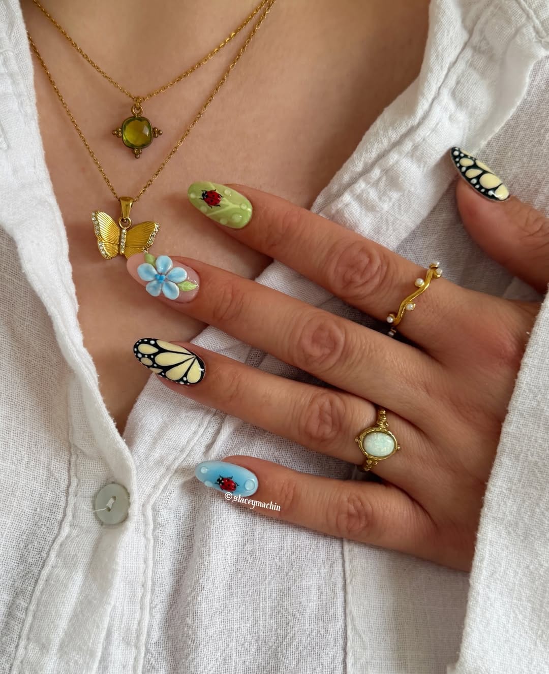 Long almond nails with 3D monarch butterfly wing, ladybird, and floral garden art