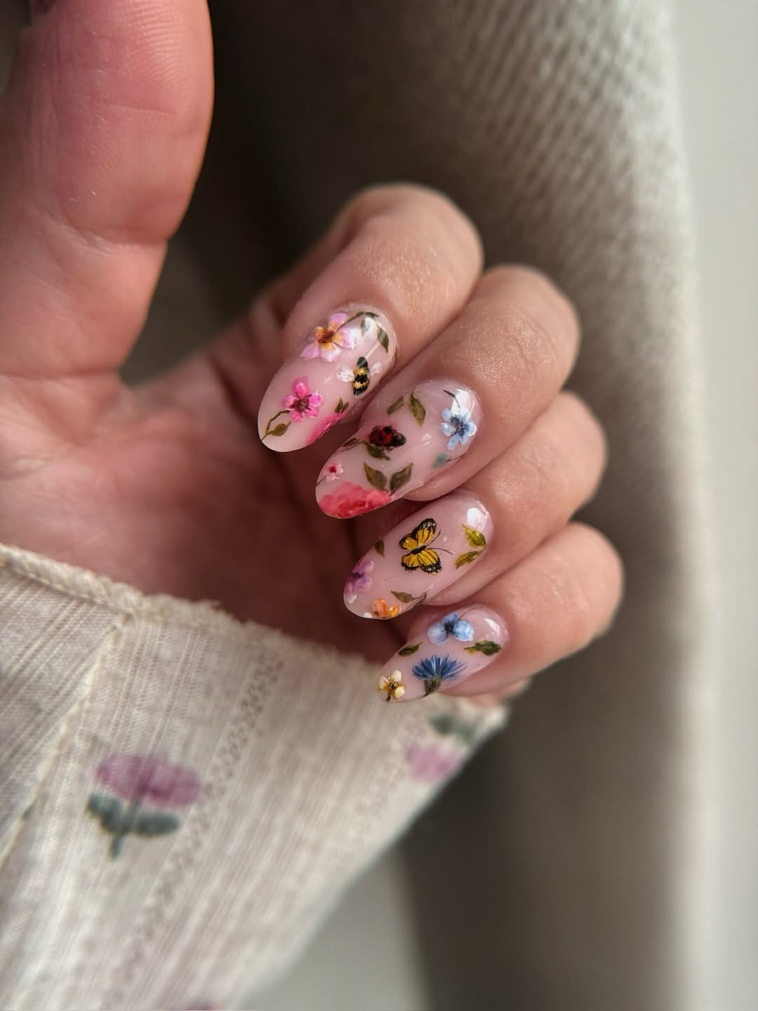 Sheer almond nails with full botanical garden scene and yellow butterfly art