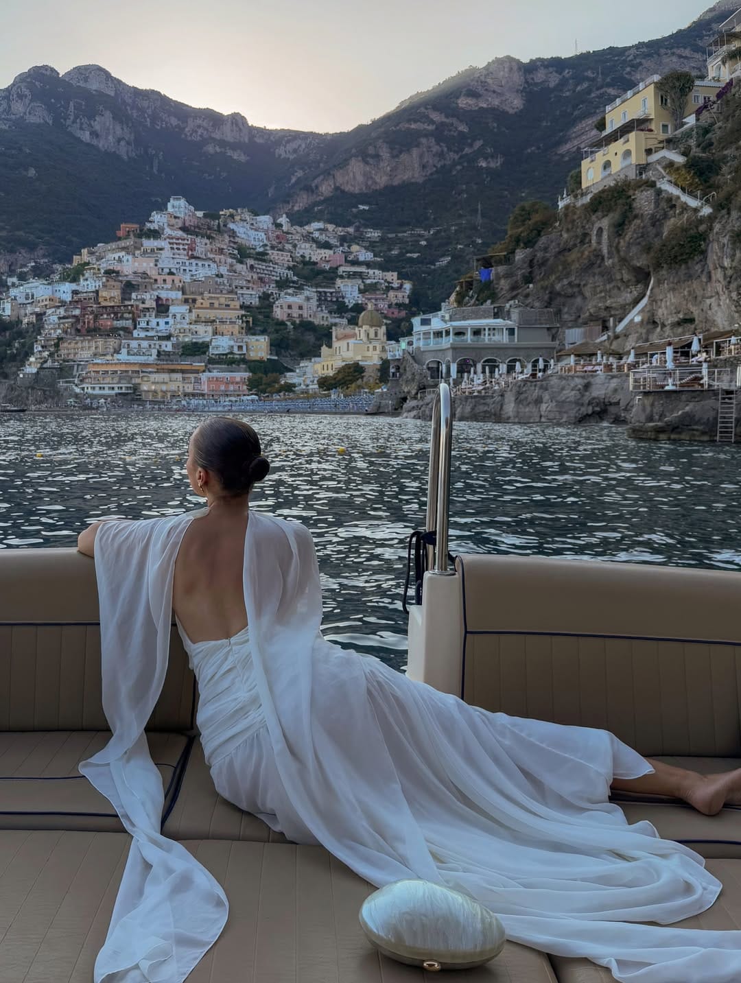 White backless chiffon maxi dress pooling at the hem on a luxury yacht in Positano