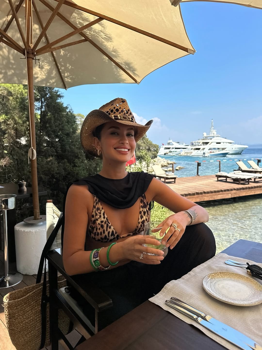 Black and white zebra print cut-out one-piece swimsuit with lace-up hip detail on a yacht in the South of France