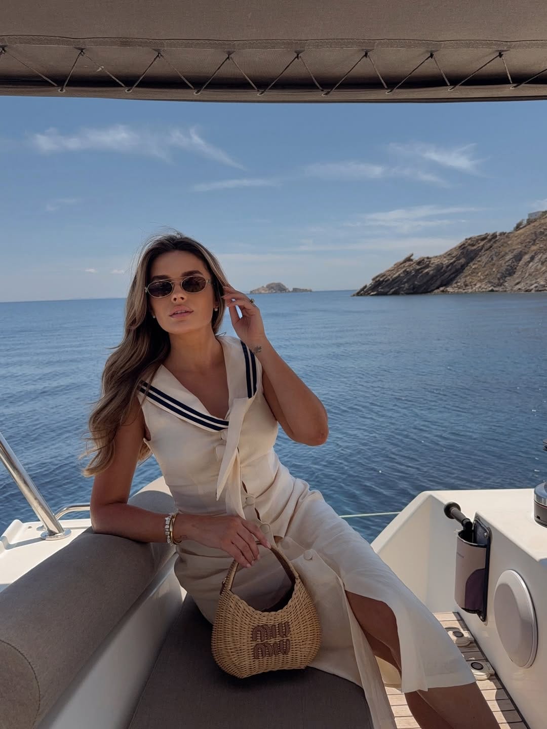 Cream nautical wrap midi dress with Miu Miu wicker bag on Greece island yacht