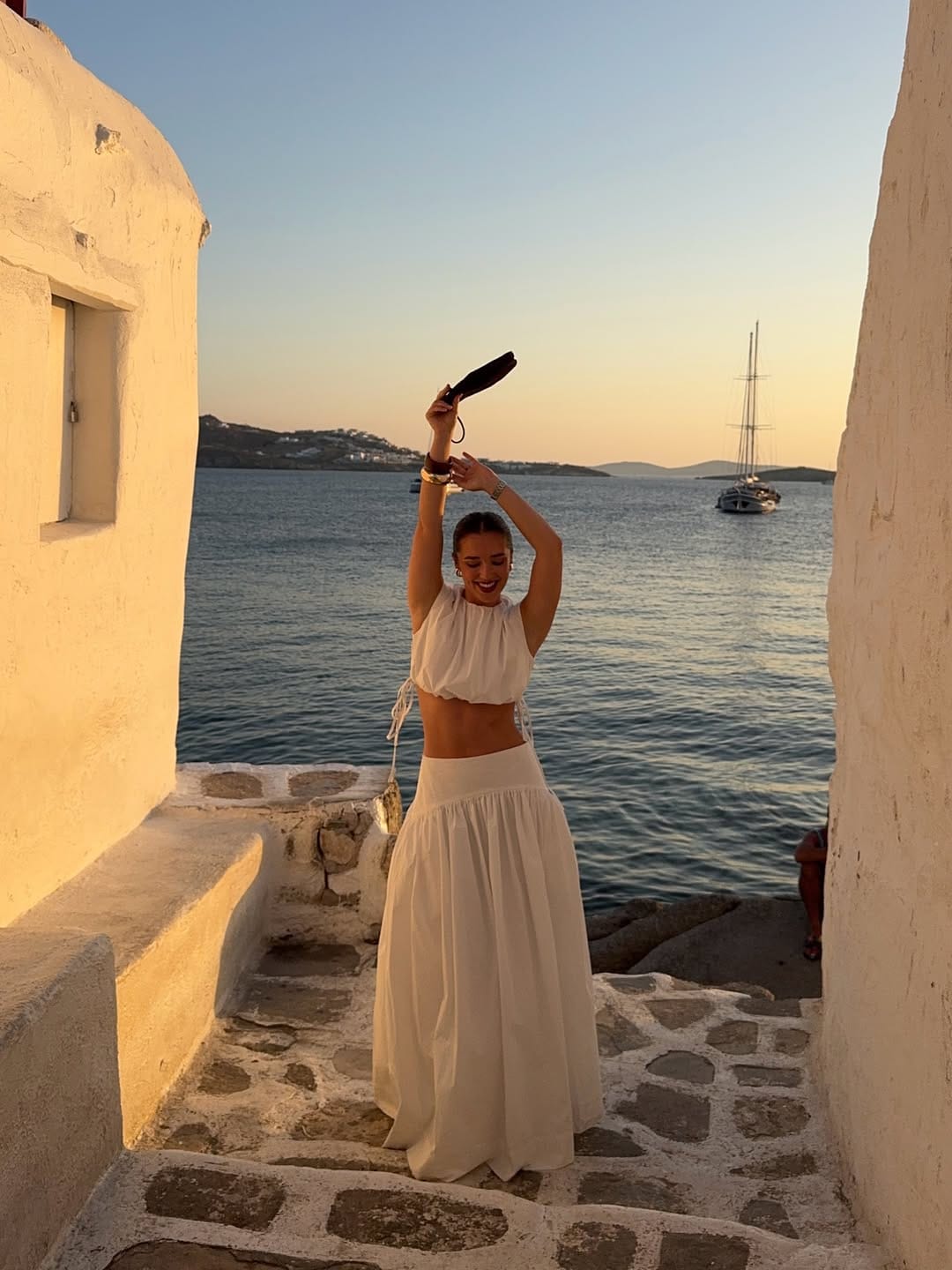 White halter crop top and tiered maxi skirt at Mykonos Greece Little Venice alleyway sunset
