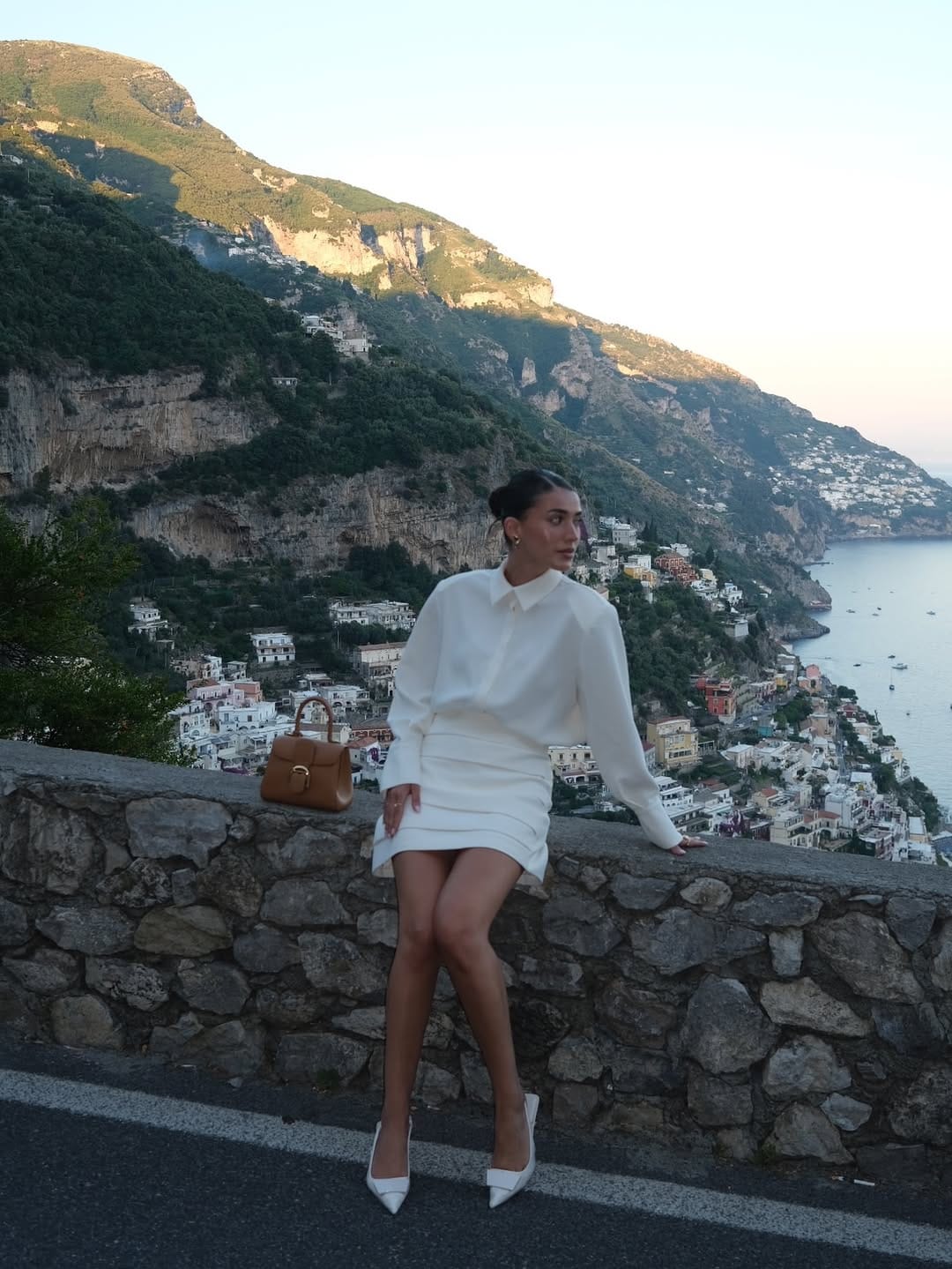 White silk oversized shirt and ruched mini skirt with tan bag and white heels, Italian summer outfit idea
