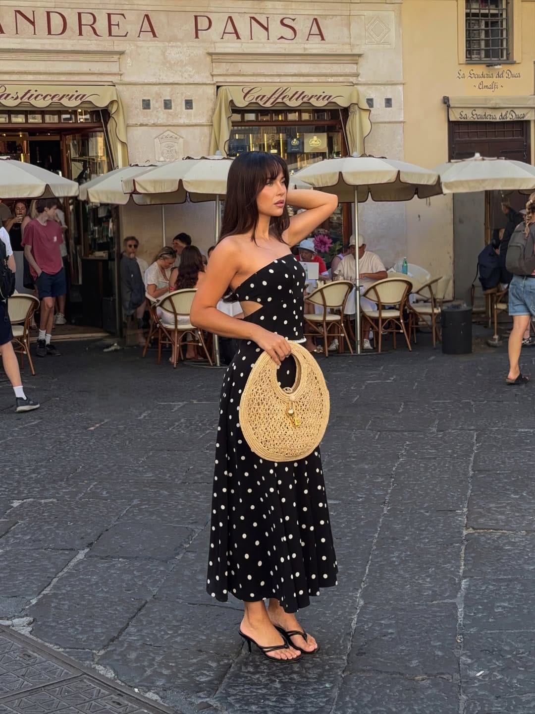Black and white polka dot strapless midi dress in Amalfi piazza with rattan Chanel bag, Italian summer look
