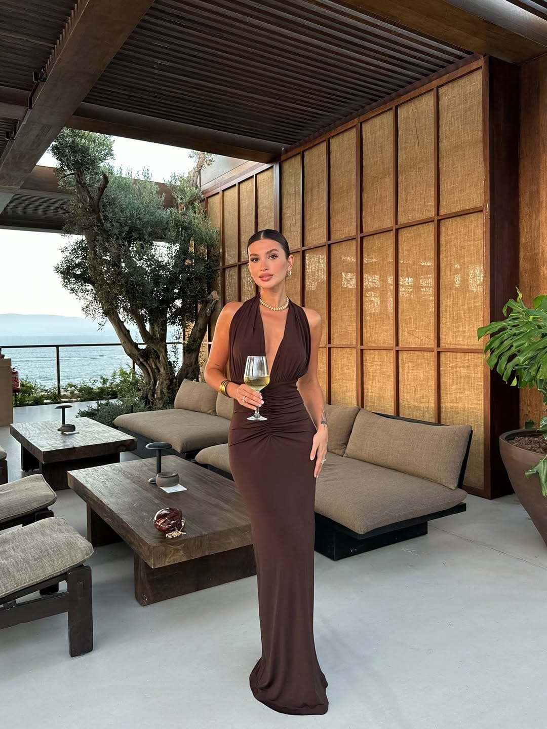 Chocolate brown ruched halter neck maxi dress with gold jewellery, Italian summer cliffside dinner outfit