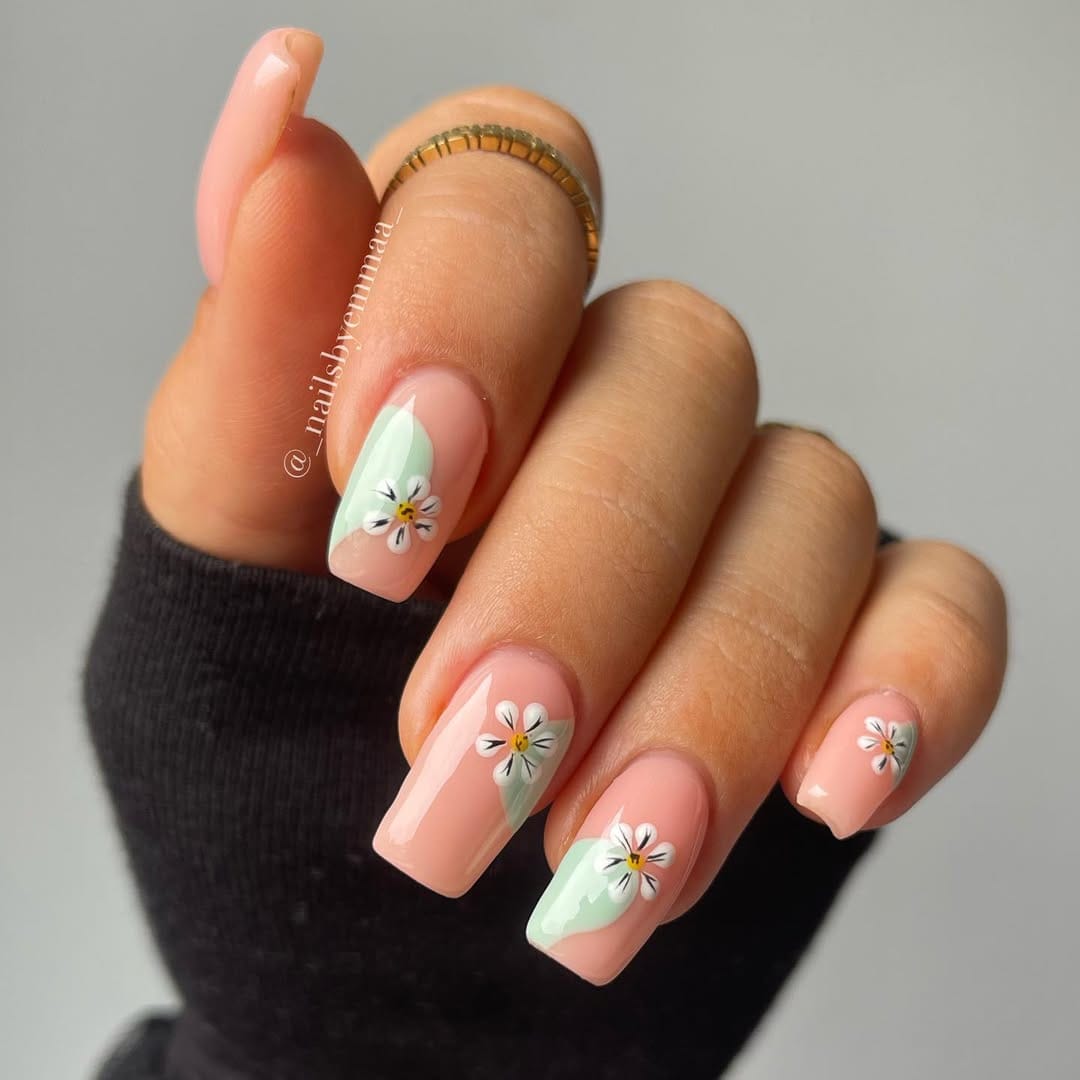 Sheer peach square nails with mint diagonal tips and white daisy nail art