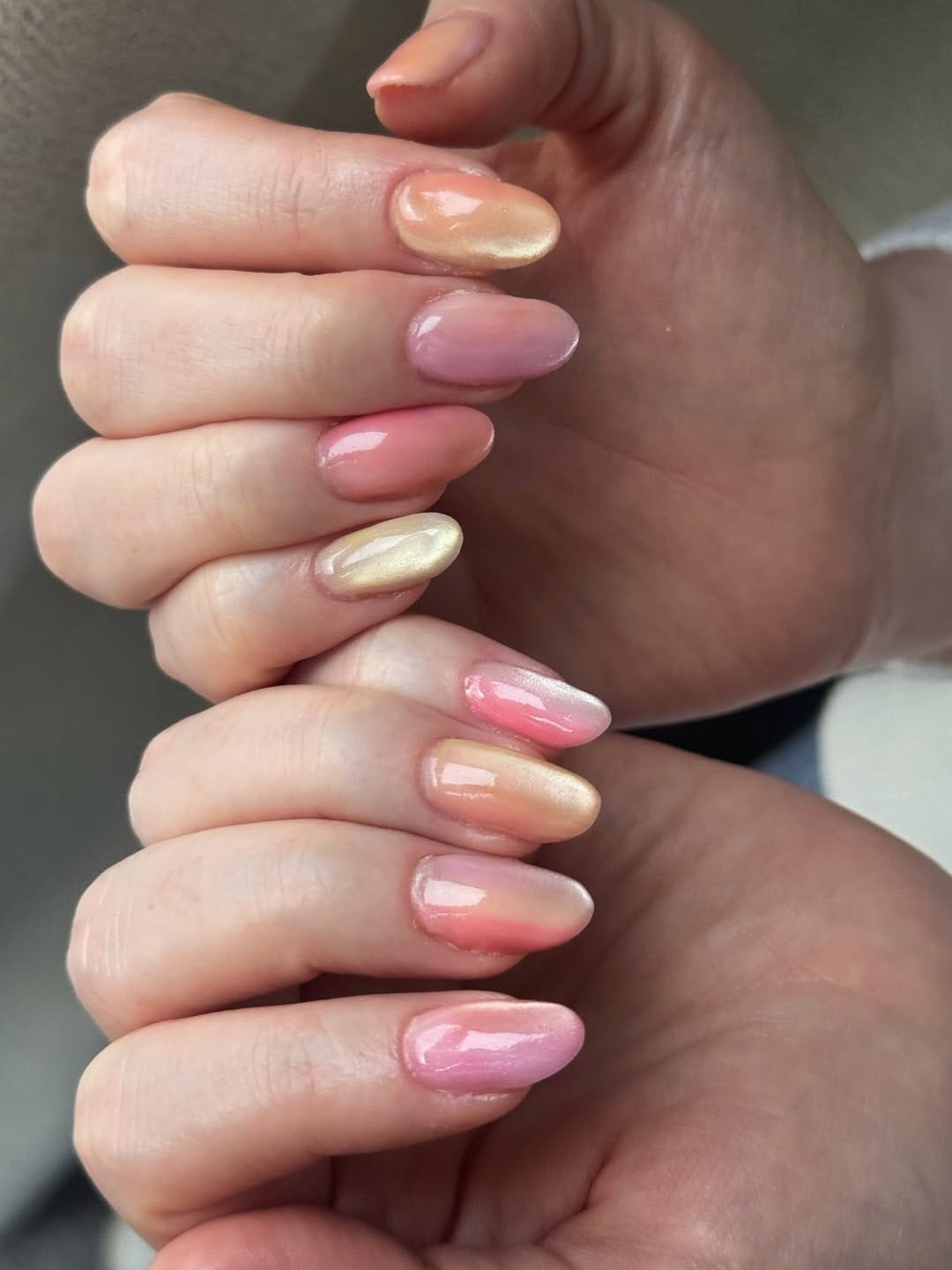 Peach pink oval nails with gold aurora chrome finish