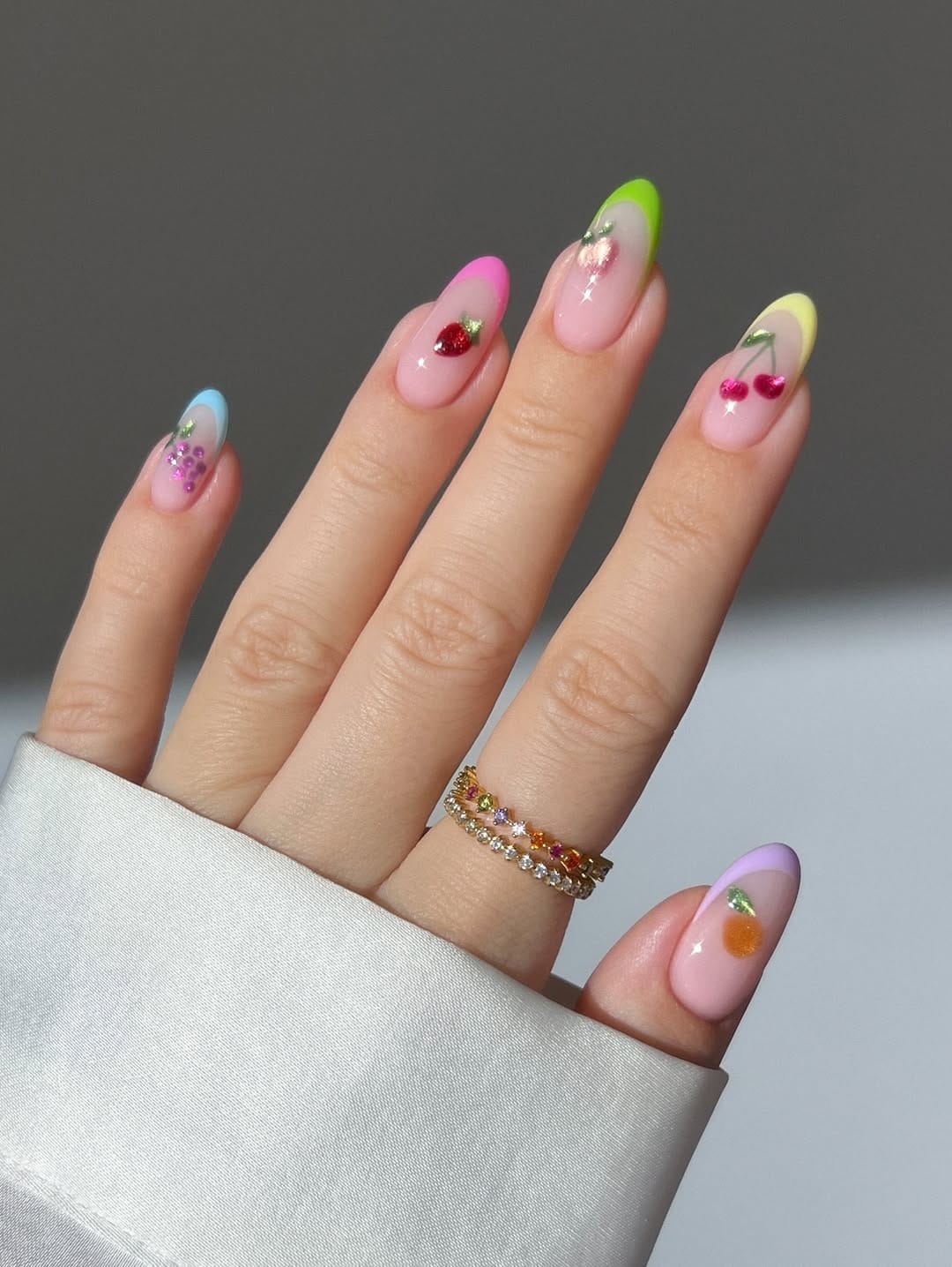 Rainbow sorbet French tip nails with glitter fruit accents