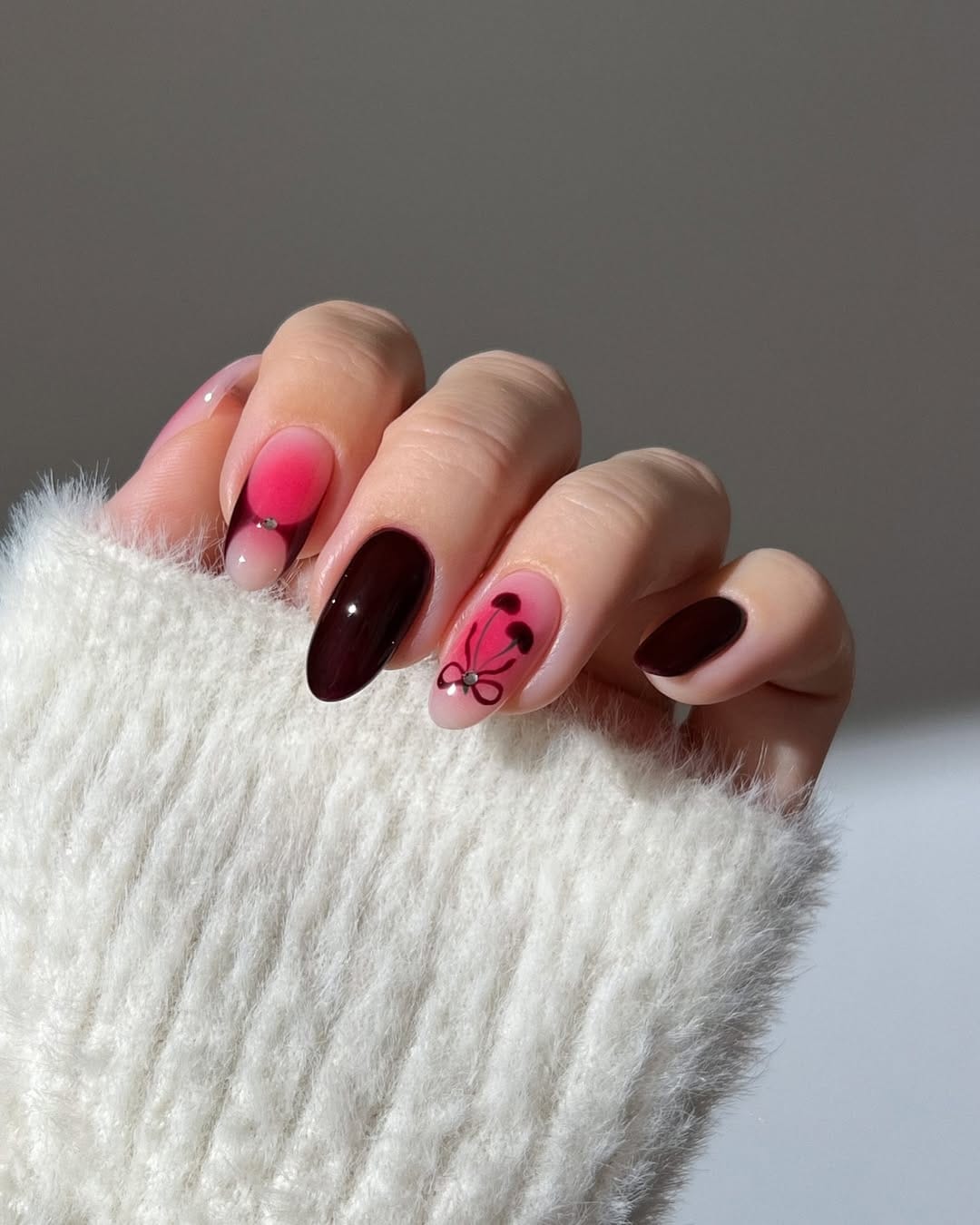 Deep burgundy and hot pink almond nails with cherry nail art