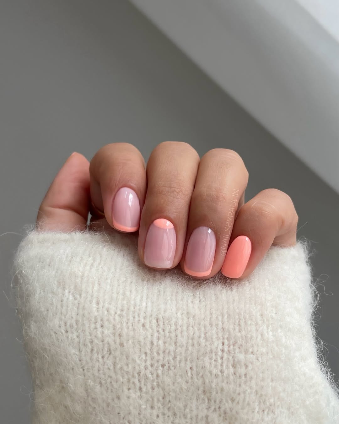 Soft pink and peach coral short square nails with half-moon accent design