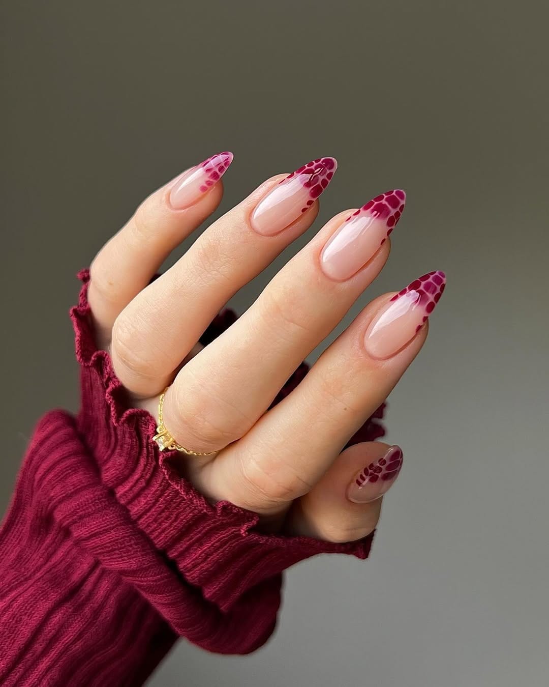 Sheer almond nails with berry pink snakeskin French tip detail