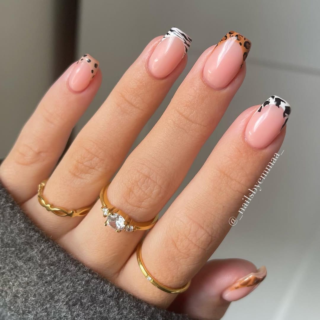 Sheer pink almond nails with mixed animal print French tip details