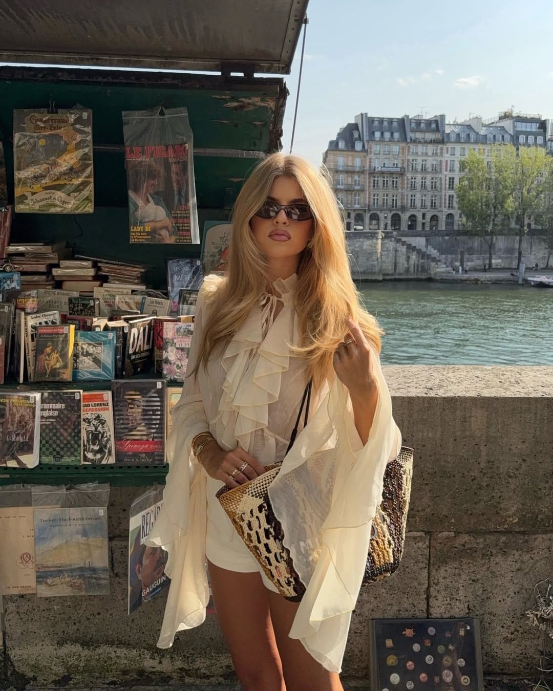 Cream ruffle-front sheer blouse paired with mini shorts styled by the Seine