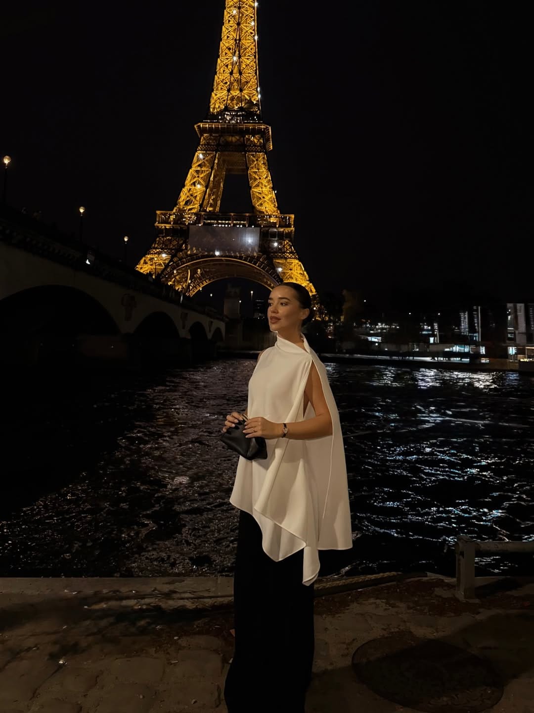 White cape top paired with black wide-leg trousers at the Eiffel Tower