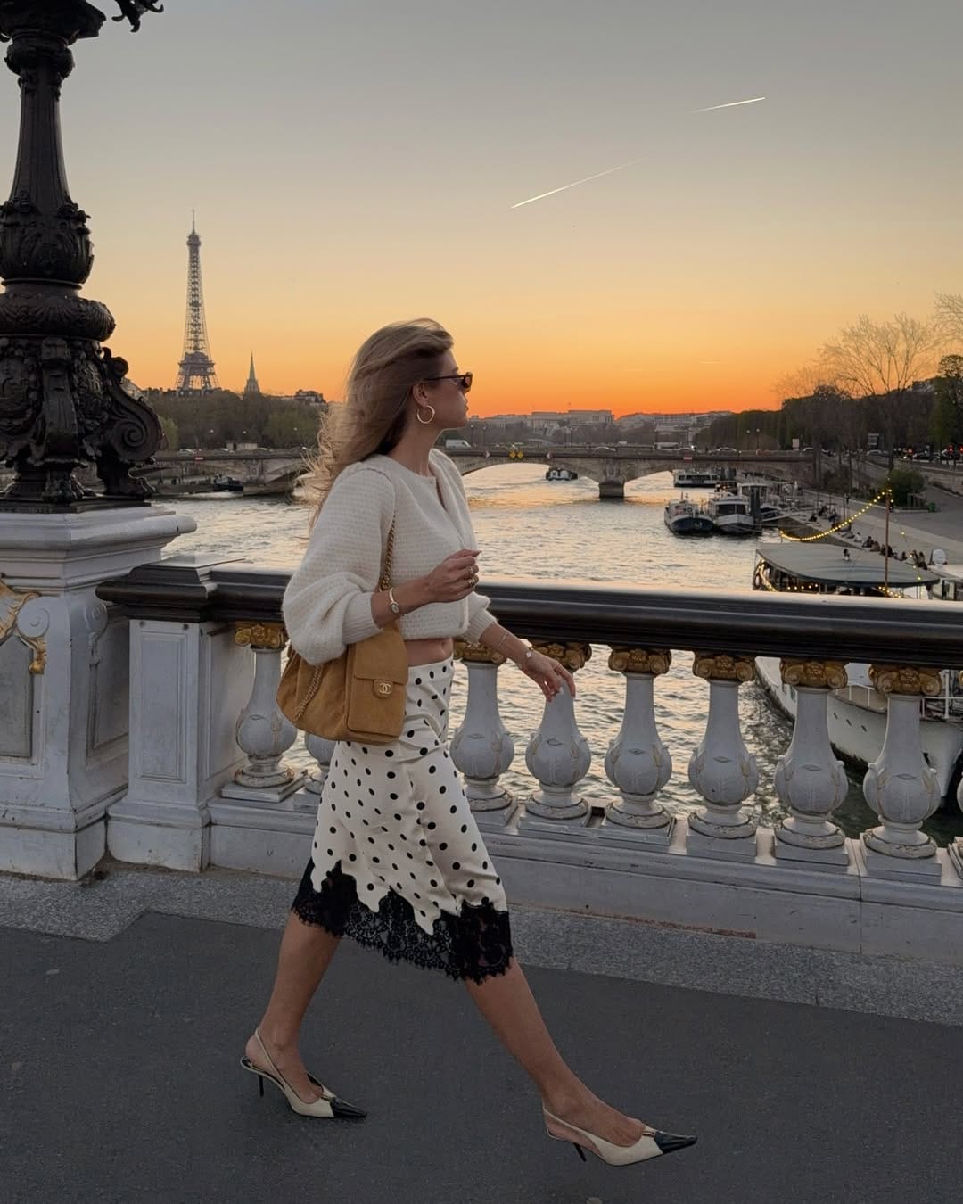 Cream knit jumper styled with a polka dot lace-hem midi skirt on Pont Alexandre III