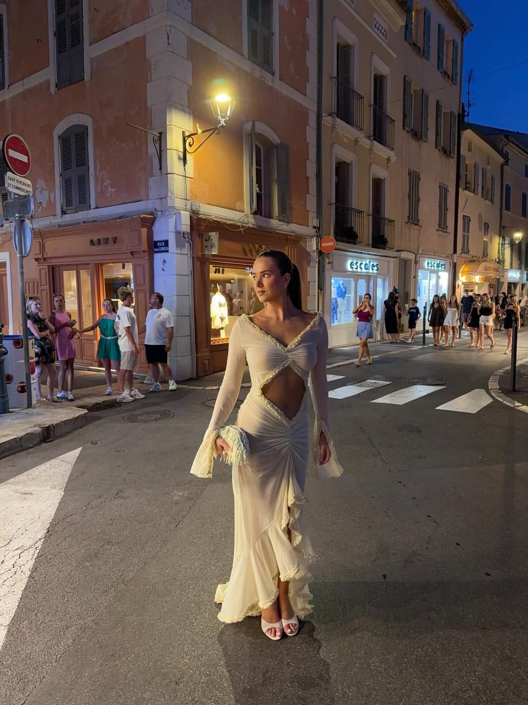 Ivory cutout ruched maxi dress with feather trim styled for a Paris night look