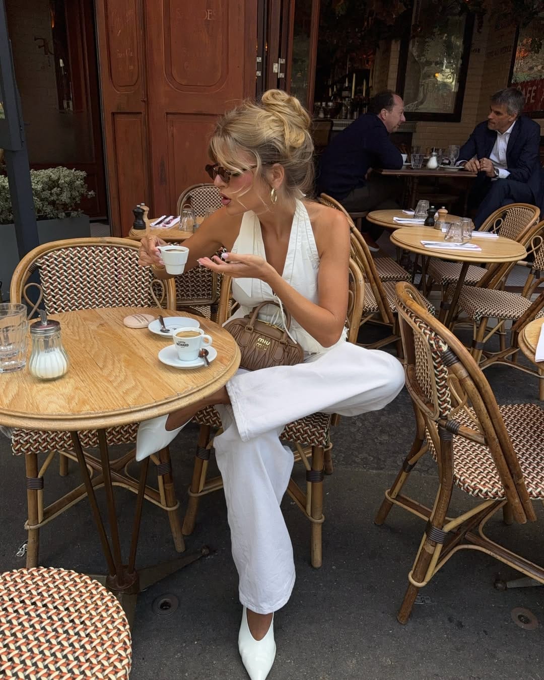 White halterneck jumpsuit styled at a Parisian café with effortless elegance