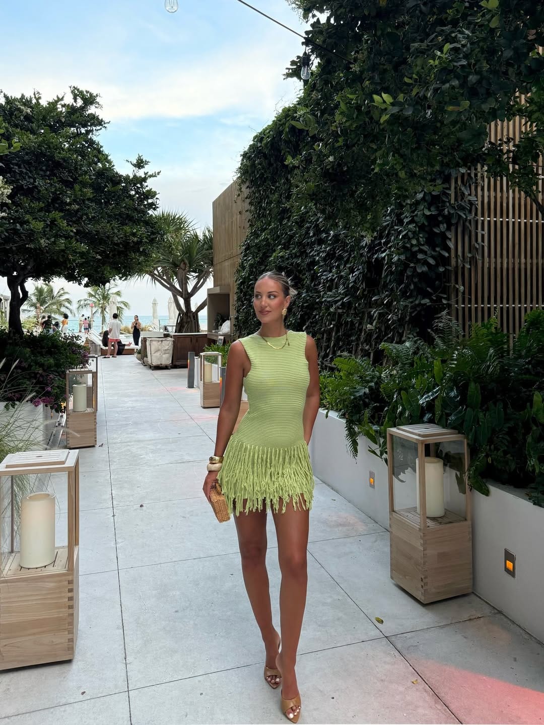 Lime green ribbed knit fringe mini dress with gold heels for a fun festival outfit.