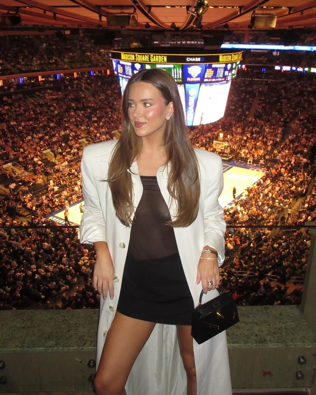 Black sheer mini dress with an oversized blazer and micro bag for a stylish concert night.