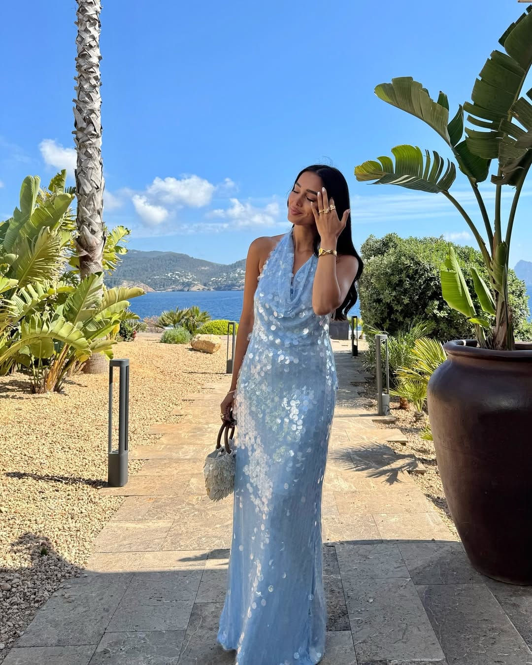 Powder blue sequin halter maxi dress with a feather bag for a statement concert outfit.
