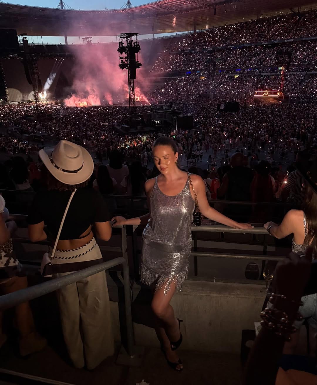 Silver chainmail fringe mini dress with a gold bag for a standout concert look.