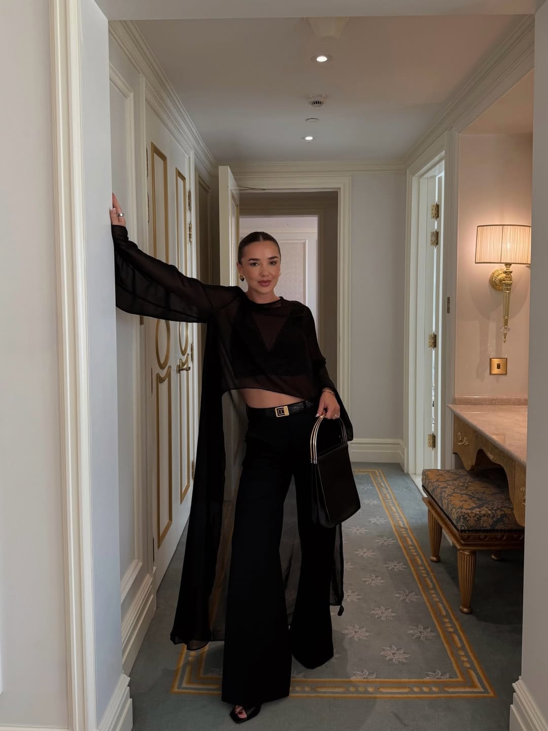 All-black sheer long-sleeve top with wide-leg trousers and a long cardigan for a cool evening concert.