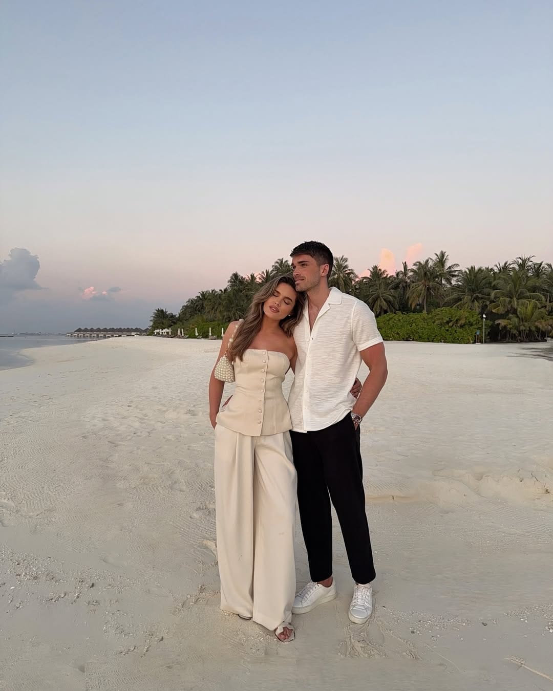 Cream strapless button-front corset top paired with wide-leg trousers