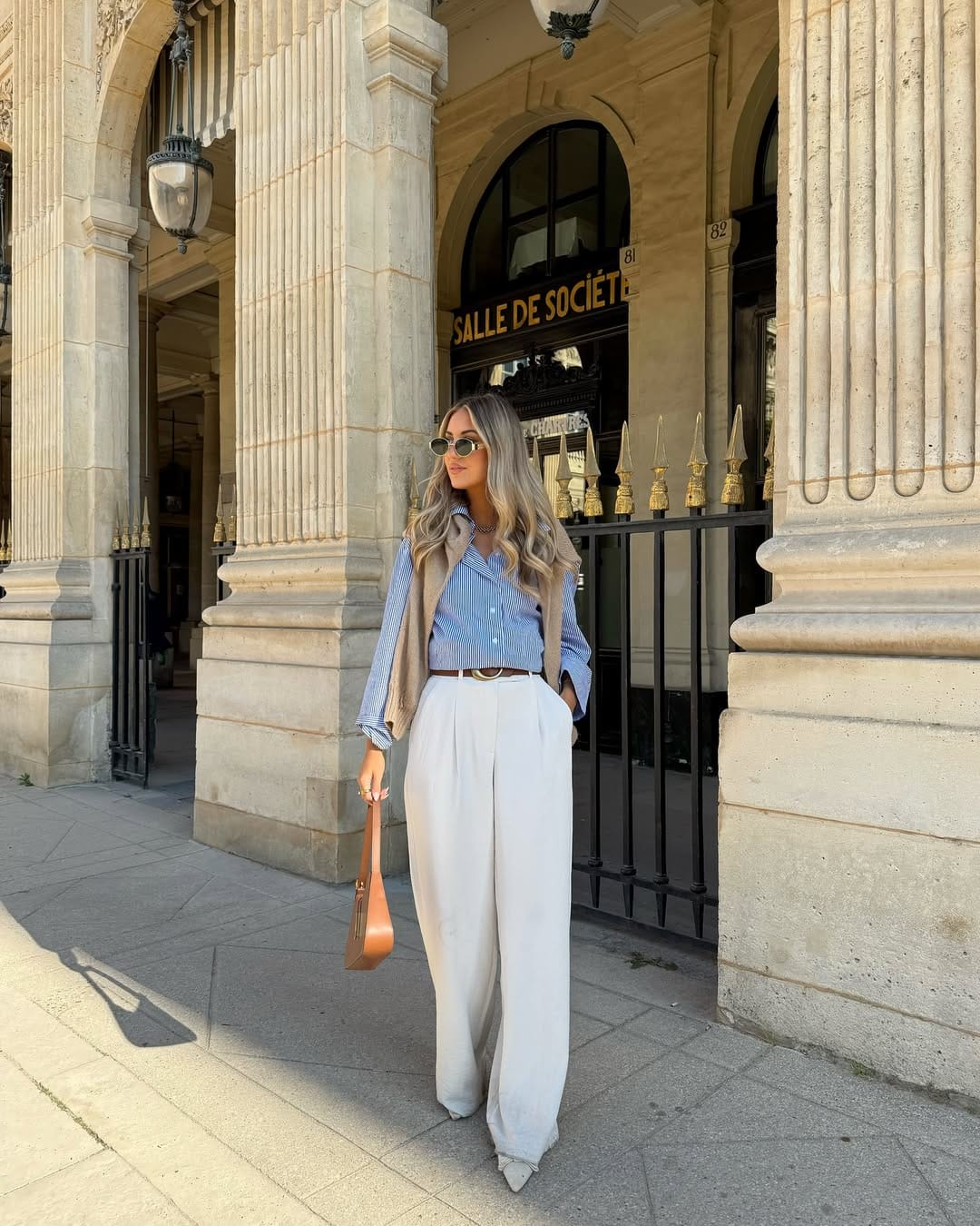 Blue stripe shirt with camel vest and cream wide-leg trousers layered work outfit