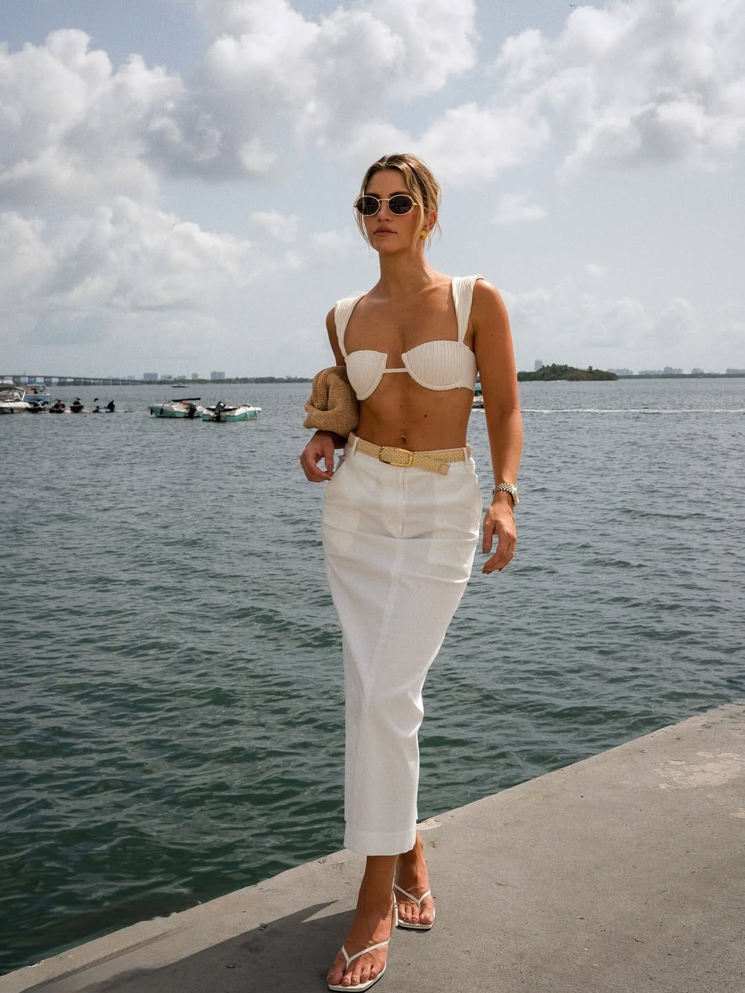 A white ribbed bandeau bikini top paired with a white linen midi skirt and a woven belt for a clean, minimal beach outfit.