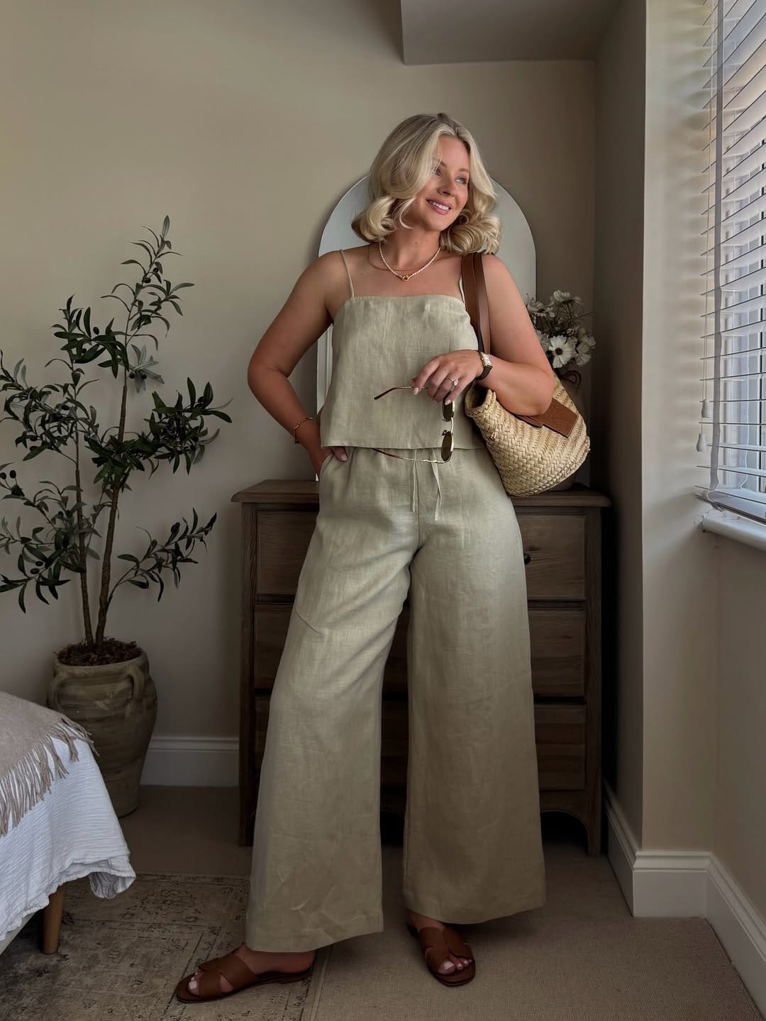 A sage green linen cami and wide-leg trouser co-ord paired with a raffia hobo bag for a soft, earthy aesthetic.